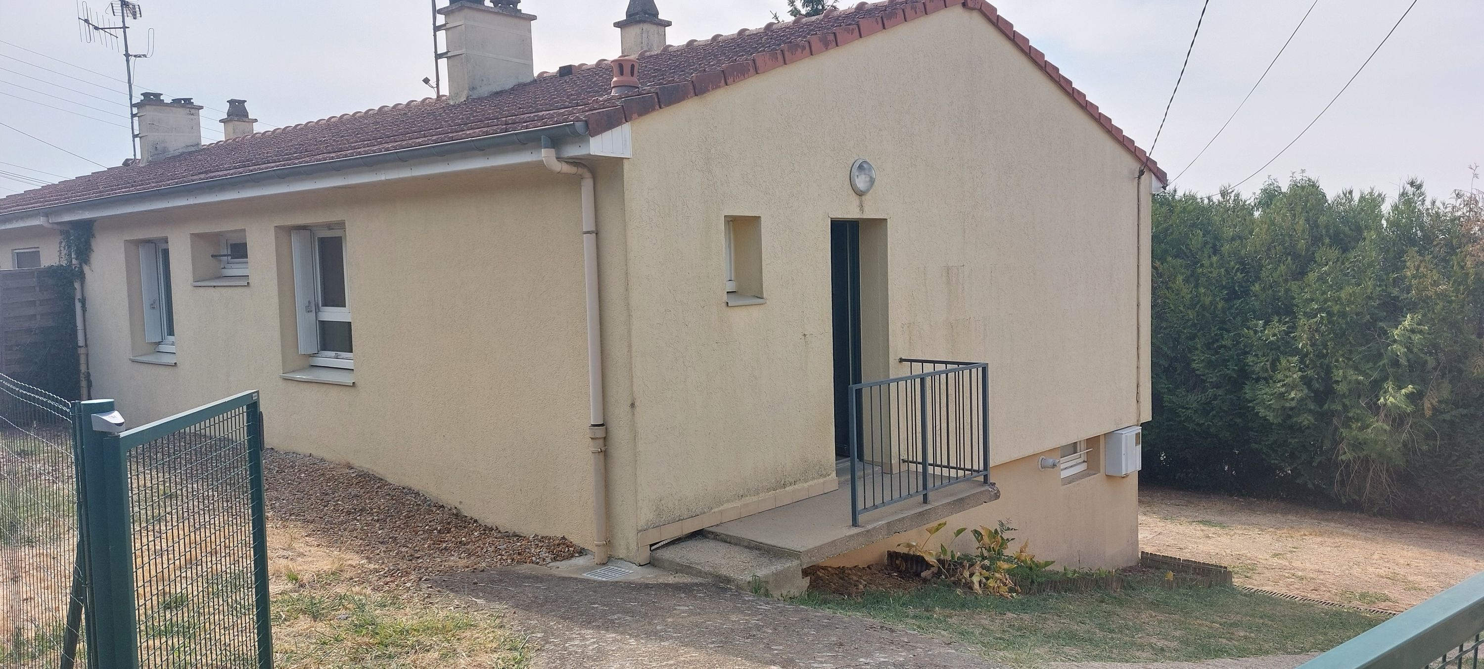 Maison de plain-pied avec jardin et garage.
